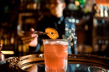 Barman is decorating rum based drink cocktail with lime