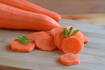 Healthy vegetables.Sliced carrots on wooden background.