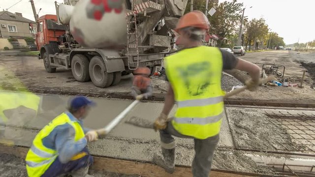 Concrete works for road construction with many workers and mixer timelapse hyperlapse
