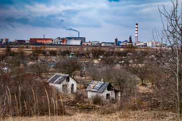 Fototapeta na wymiar Abandoned houses on the background of the industrial zone