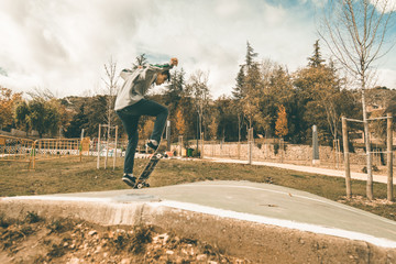 Guy skateboarding in a park. Skateboarder jumping on skateboard