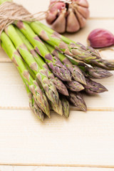 Bunch of fresh asparagus on wooden table.