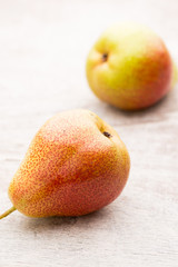 Fresh pears with leaves in a on wooden background.