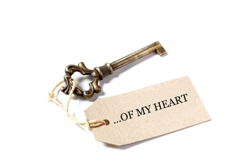 old antique key with a label with the words ...of my heart isolated  on white background with copy space