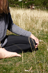 Woman meditating and doing yoga on the top of a mountain in nature