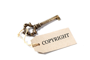 old antique key with a label and the word copyright isolated on white background with copy space