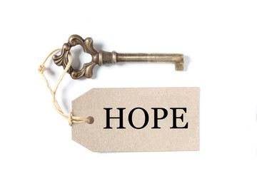 old antique key with a label and the word hope isolated on white background with copy space
