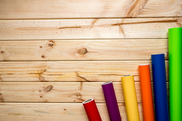 Colorful vinyl rolls on wooden background placed in a row