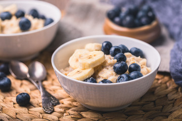 Healthy oatmeal porridge breakfast with blueberries and sliced banana