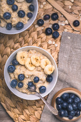 Healthy oatmeal porridge breakfast with blueberries and sliced banana