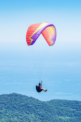 Paraglider over the sea coast. Russia, Republic of Crimea. 06.13.2018. Flight of a paraglider athlete over the sea coast in the area of Mount Ai-Petri
