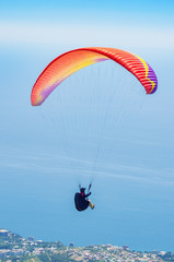 Paraglider over the sea coast. Russia, Republic of Crimea. 06.13.2018. Flight of a paraglider athlete over the sea coast in the area of Mount Ai-Petri