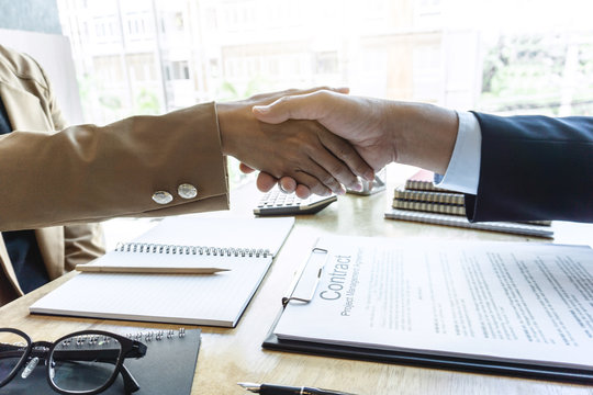 Finishing up a meeting, handshake of two happy business people after contract agreement to become a partner, collaborative teamwork