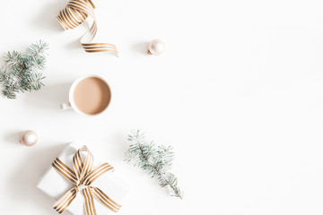 Christmas composition. Gift, fir tree branches, cup of coffee, balls on white background....