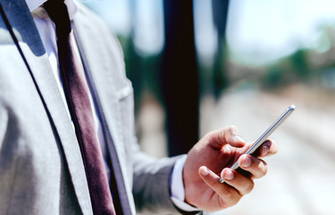 Close up of businessman's hand holding smart phone.