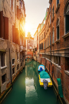 Street canal in Venice, Italy. Narrow canal among old colorful brick houses in Venice, Italy. Venice postcard
