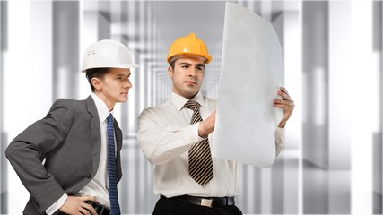 Two engineers men at construction site watching blueprint