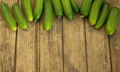Fresh cucumbers on old wooden table