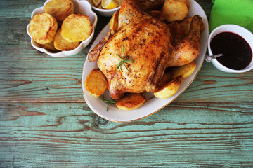 Whole roasted chicken with potatoes and lemon. Top view