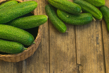 Fresh cucumbers in box and on old wooden table
