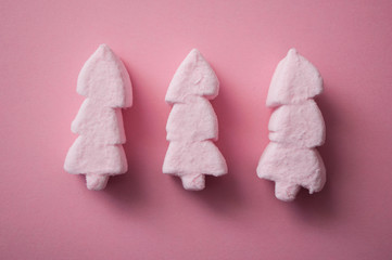 closeup of pink marshmallows in shaped fir on pink background