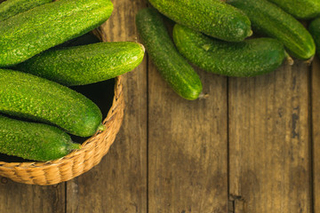 Fresh cucumbers in box and on old wooden table