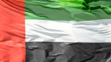 Plain crop view of crumpled United Arab Emirates UAE national state sign flag waving by wind natural colors exterior panoramic landscape background view patriotic theme scene