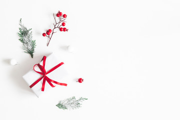 Christmas composition. Frame made of gift, snowflakes, fir tree branches and red berries on white background. Christmas, winter, new year concept. Flat lay, top view, copy space