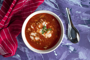 A view of a bowl of tomato soup with sour cream.