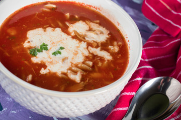 A view of a bowl of tomato soup with sour cream.