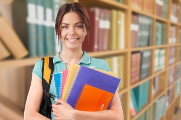 Young female student with notebooks at library