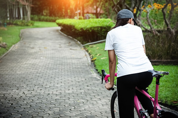 Fototapeta premium The woman is riding bicycle in a park,blurry light around