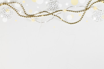 The Christmas concrete white background with snowflakes, garland and shine.