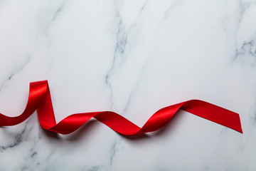 Red satin ribbon on a luxury marble background
