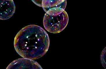 Multicolored soap bubbles close up on a black background	