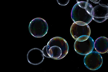 Multicolored soap bubbles close up on a black background	