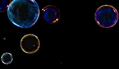 Obraz na płótnie Canvas Multicolored soap bubbles close up on a black background 