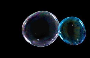 Multicolored soap bubbles close up on a black background	