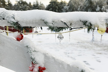A wooden fence on a farm decorated with New Year's Christmas toys and garlands. USA. Maine.
