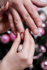 The bride wears the ring to groom's finger at wedding day. Love, happy marry concept. Christmas concept. Close up.
