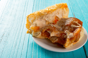 side view studio shot of bread with chicken with the last bit