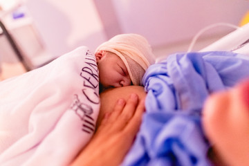 Newborn baby on his mother's chest in the hospital.