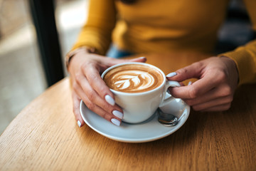 Drinking coffee in the cafe. Close-up.