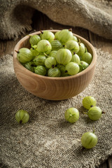 Fresh gooseberry in a wooden bowl.