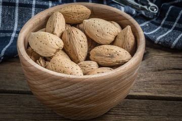 Almonds in-shell in wooden bowl.