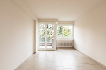 Empty room with radiators and large windows overlooking nature