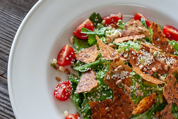 Vegetarian dish: Caesar salad made from lettuce leaves, tomatoes, sprouted seeds, sesame with Caesar sauce