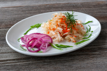 Vegetarian dish. Sauerkraut with carrots, red onions, decorated with greens