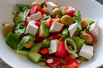 Vegetarian dish: Salad with Tofu cheese, with cucumbers, onions, sweet peppers, lettuce and sprouted seeds