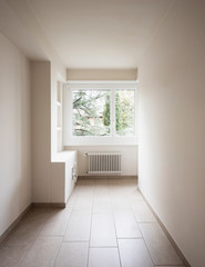 Empty room with radiators and large windows overlooking nature